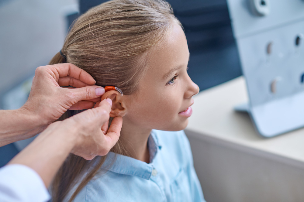 doctors-hands-trying-hearing-aid-girl.jpg